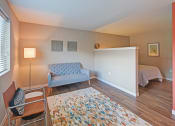 Thumbnail 4 of 11 - a living room with a couch and a chair and a bed