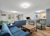 Thumbnail 13 of 19 - a living room with blue couches and chairs and a wooden coffee table