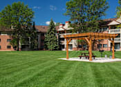 Thumbnail 26 of 32 - Large manicured lawn with a sun terrace over a park bench