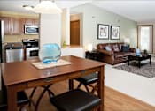 Thumbnail 10 of 32 - Dining room and living room areas with a large leather couch and a rectangular brown table