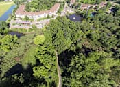 Thumbnail 31 of 32 - High altitutde view of property, showing buildings, trees, and a bike trail