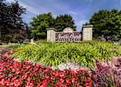 Thumbnail 22 of 26 - A sign for North Point Apartments is surrounded by flowers and greenery.