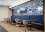 Thumbnail 9 of 44 - Banquette with blue cushions and a TV on the back wall