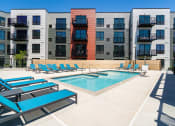 Thumbnail 14 of 44 - Community outdoor pool surrounded by blue pool chairs