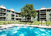Thumbnail 1 of 19 - A swimming pool in front of apartment buildings.