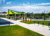 Thumbnail 39 of 44 - Outdoor playground with green and blue awnings and a walking path
