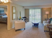 Thumbnail 22 of 23 - a living room with a couch and a chair and a table