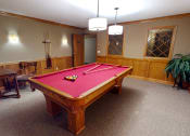 Thumbnail 20 of 26 - a red pool table in a room with a wooden table and chairs