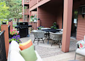 Thumbnail 13 of 25 - A patio with a table and chairs and a grill.
