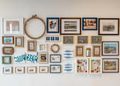 Thumbnail 8 of 22 - A wall filled with many different pictures and a wreath.