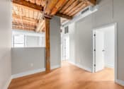 Thumbnail 15 of 22 - A room with wooden floors and a wooden beam on the ceiling.
