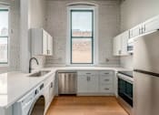 Thumbnail 18 of 22 - A kitchen with white cabinets and a large window.