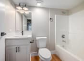 Thumbnail 22 of 22 - A white bathroom with a toilet, sink, and bathtub.