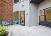 Thumbnail 2 of 76 - A patio with a blue chair and a table.