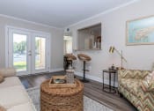 Thumbnail 8 of 20 - a living room with a couch and a table and a door at Sawgrass Apartments, Charleston