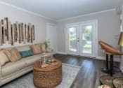 Thumbnail 11 of 20 - a living room with a couch and a door to a patio at Sawgrass Apartments, Charleston, South Carolina