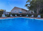Thumbnail 2 of 20 - a swimming pool with chairs and a house in the background at Sawgrass Apartments, South Carolina, 29412