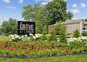 Thumbnail 1 of 32 - the grove apartments sign in front of flowers and plants at The Grove at Lyndon, Louisville