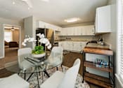 Thumbnail 16 of 19 - a kitchen and dining room with white cabinets and a glass table at Hyde Park Townhomes, PRG Real Estate Management, Chester, VA