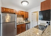 Thumbnail 18 of 22 - A kitchen with granite countertops and stainless steel appliances.