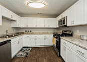 Thumbnail 17 of 19 - a kitchen with white cabinets and a black stove and microwave at Hyde Park Townhomes, PRG Real Estate Management, Chester, VA