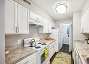 Thumbnail 14 of 25 - A kitchen with white cabinets and a stove top oven at Chinoe Creek Apartments, Lexington 40502