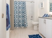 Thumbnail 16 of 26 - a bathroom with a white toilet and a blue shower curtain  at The Point on 38th, Norfolk
