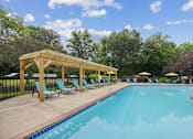 Thumbnail 2 of 32 - a swimming pool with blue chairs and a wooden pavilion next to it at The Grove at Lyndon, Louisville