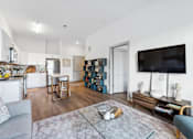 Thumbnail 14 of 26 - a living room with a couch a table a television and a kitchen in the background  at The Point on 38th, Norfolk