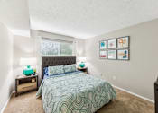 Thumbnail 18 of 25 - A bedroom with a bed, nightstands, and pictures on the wall at Chinoe Creek Apartments, Lexington