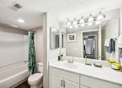 Thumbnail 17 of 25 - A white bathroom with a toilet, sink, and mirror at Chinoe Creek Apartments, Lexington, KY