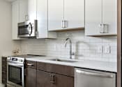 Thumbnail 3 of 43 - A kitchen with white cabinets and a stainless steel dishwasher at The Carousel, Richmond, VA