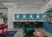 Thumbnail 27 of 43 - A room with a blue wall and a white table with chairs at The Carousel Apartments, Richmond, VA
