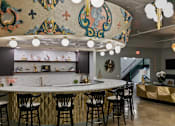 Thumbnail 9 of 43 - A bar with a gold and black counter and chairs at The Carousel Apartments, Richmond