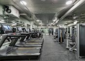 Thumbnail 23 of 43 - A gym with treadmills and exercise equipment at The Carousel Apartments, Virginia