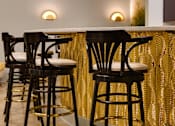 Thumbnail 11 of 43 - A set of four black bar stools with gold accents at The Carousel Apartments, Richmond, VA