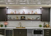 Thumbnail 13 of 43 - A kitchen with dark brown cabinets and a white countertop at The Carousel Apartments, Richmond, VA, 23220