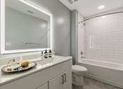 Thumbnail 49 of 51 - A white bathroom with a toilet, sink, and bathtub at The Carousel Apartments, Richmond, Virginia
