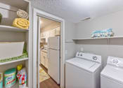 Thumbnail 21 of 25 - A laundry room with a white washer and dryer at Chinoe Creek Apartments, Lexington, KY, 40502