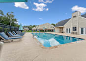 Thumbnail 2 of 22 - A pool with a blue umbrella and lounge chairs.