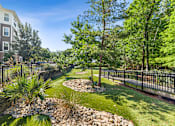 Thumbnail 13 of 26 - A well-maintained garden with a small stream running through it at Proximity Apartments, South Carolina, 29414