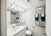 Thumbnail 19 of 25 - A white bathroom with a toilet, sink, and towel rack at Chinoe Creek Apartments, Lexington, Kentucky