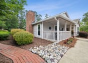 Thumbnail 6 of 19 - the front porch of a white house with a walkway and rocks at Chapel View Apartments in Chapel Hill, NC