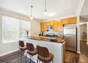 Thumbnail 26 of 29 - Kitchen with Bar and Yellow Furniture at 45 Madison Apartments, Missouri, 64111