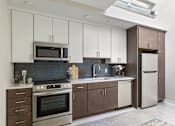 Thumbnail 34 of 43 - A kitchen with white cabinets and a black stove top oven at The Carousel Apartments, Richmond, Virginia