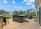 Thumbnail 16 of 31 - a hot tub on a deck with chairs and trees in the background at Linkhorn Bay Apartments, Virginia Beach, VA