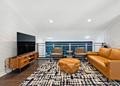 Thumbnail 12 of 31 - a living room with a leather couch and chairs and a flat screen tv on the wall at Linkhorn Bay Apartments, Virginia