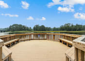 Thumbnail 17 of 31 - a circular deck with benches overlooking a lake at Linkhorn Bay Apartments, Virginia Beach 23451