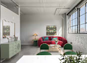 Thumbnail 37 of 43 - A room with a red couch, green chairs, and a white table at The Carousel Apartments, Richmond, Virginia