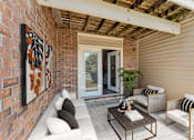 Thumbnail 22 of 22 - A patio with a white couch, a coffee table, and a painting on the wall.